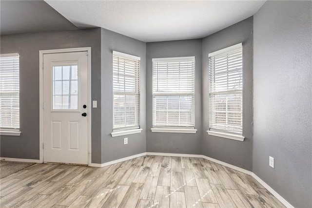 entryway featuring baseboards and light wood finished floors