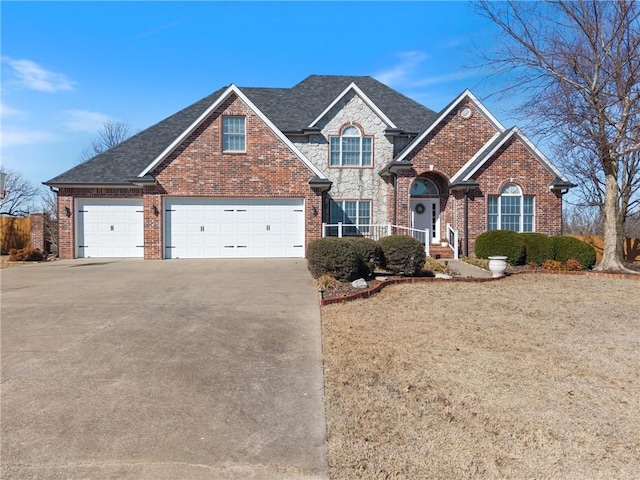 traditional-style house with stone siding, brick siding, roof with shingles, and driveway