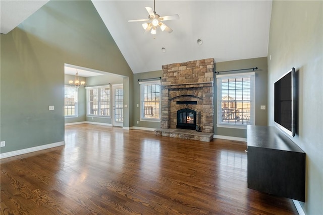 unfurnished living room featuring ceiling fan with notable chandelier, wood finished floors, plenty of natural light, and a fireplace