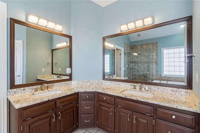 full bathroom with double vanity, tile patterned flooring, a shower stall, and a sink