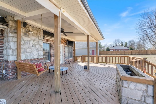 wooden terrace with ceiling fan and fence