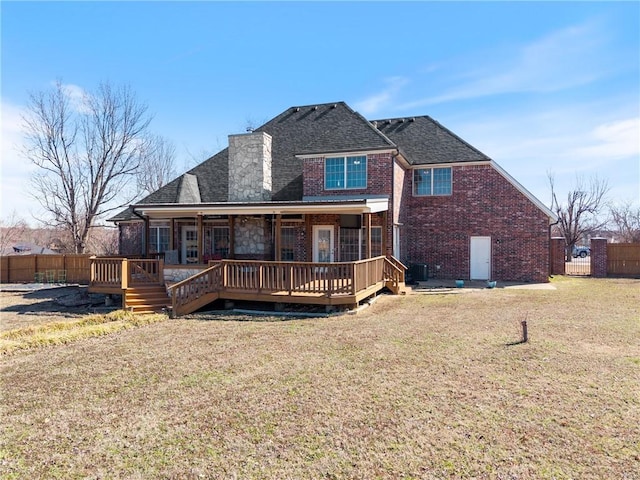 back of house with a yard, brick siding, central AC, and fence