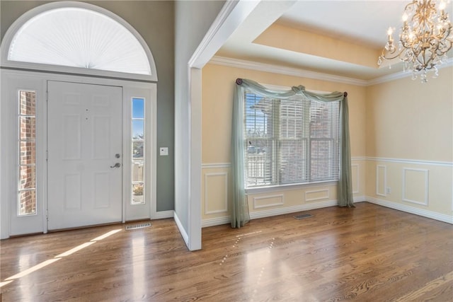 5102 Grove Dr, Rogers, AR 72758 - entrance foyer with a notable chandelier, wainscoting, a decorative wall, wood finished floors, and visible vents