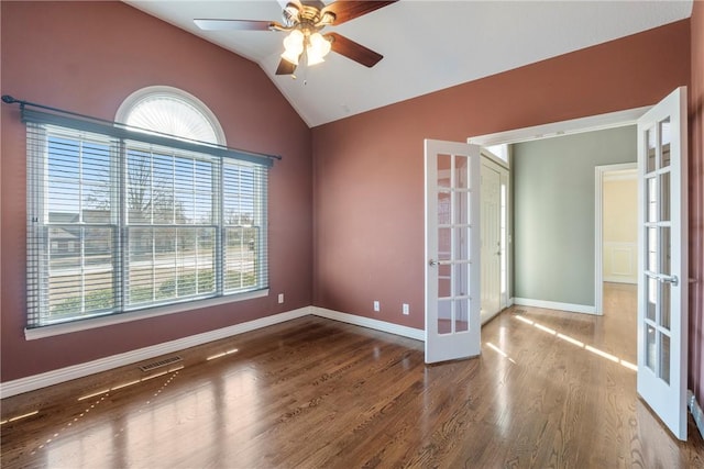 spare room featuring wood finished floors, visible vents, baseboards, lofted ceiling, and french doors