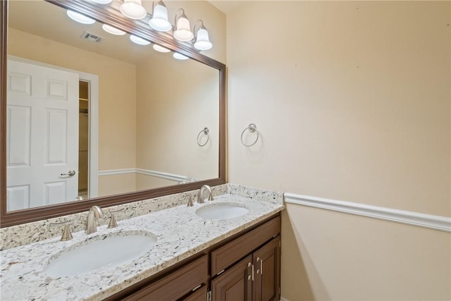 bathroom with a sink, visible vents, and double vanity