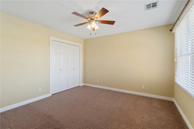 unfurnished bedroom with visible vents, a ceiling fan, a closet, carpet floors, and baseboards