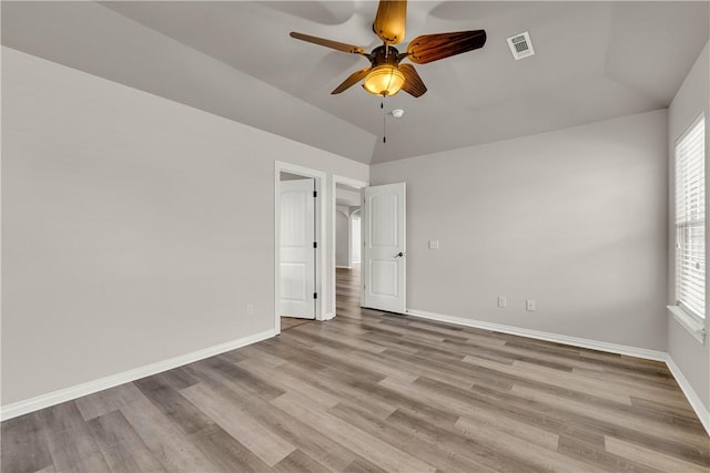 unfurnished room featuring wood finished floors, visible vents, and a healthy amount of sunlight