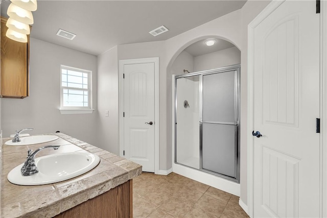 bathroom featuring a sink, visible vents, and a stall shower