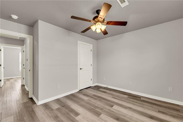 spare room featuring visible vents, baseboards, and wood finished floors