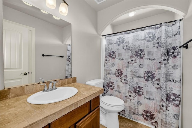 bathroom featuring tile patterned flooring, toilet, vanity, and a shower with curtain