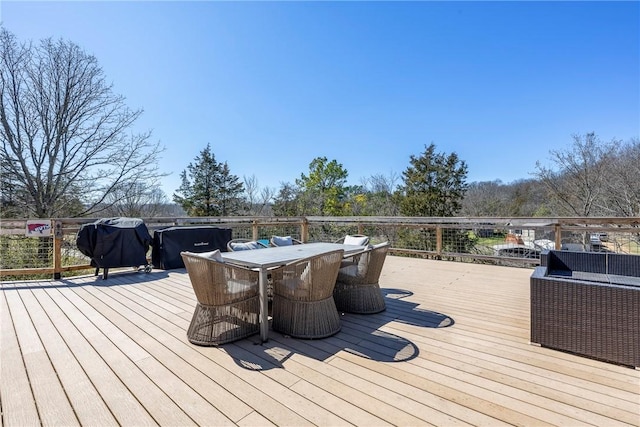 deck with outdoor dining space and area for grilling