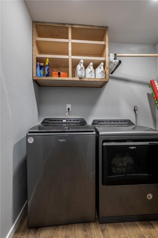 washroom with laundry area, wood finished floors, baseboards, and washer and clothes dryer