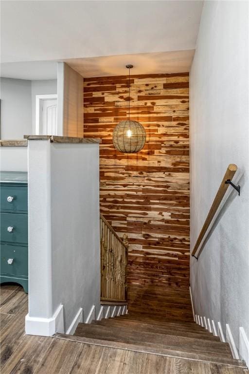 staircase featuring wood walls and wood finished floors