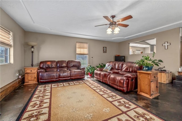 living area with concrete flooring, ceiling fan, and a healthy amount of sunlight