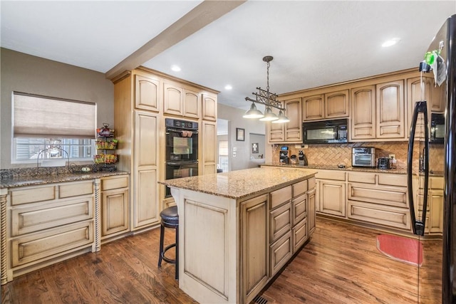 kitchen with a center island, light stone countertops, dark wood finished floors, decorative backsplash, and black appliances