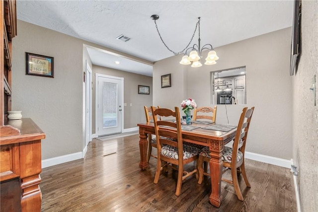 dining space featuring visible vents, baseboards, and wood finished floors