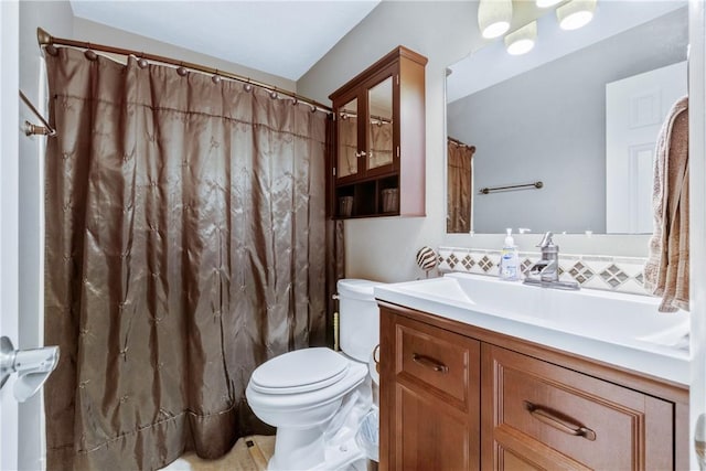 bathroom featuring backsplash, toilet, and vanity