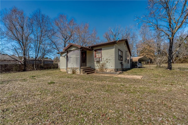 exterior space with a detached carport, a lawn, and entry steps