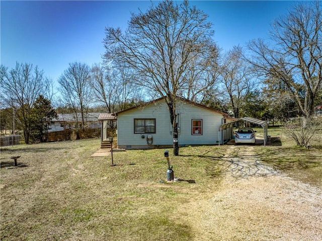 view of property exterior featuring crawl space, a lawn, a detached carport, and driveway