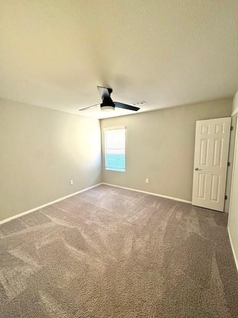 empty room with baseboards, ceiling fan, and carpet flooring