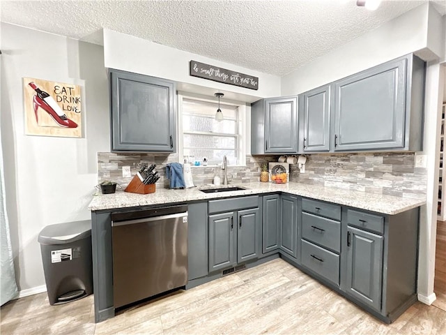 kitchen featuring dishwasher, decorative backsplash, gray cabinets, and a sink