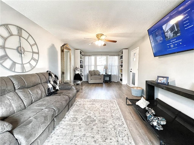 living area with a textured ceiling, wood finished floors, and a ceiling fan