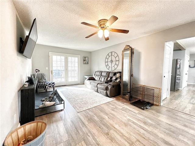 living area with a textured ceiling, wood finished floors, and ceiling fan