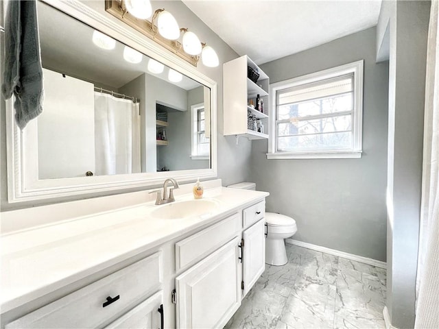 full bath featuring a wealth of natural light, baseboards, marble finish floor, and vanity