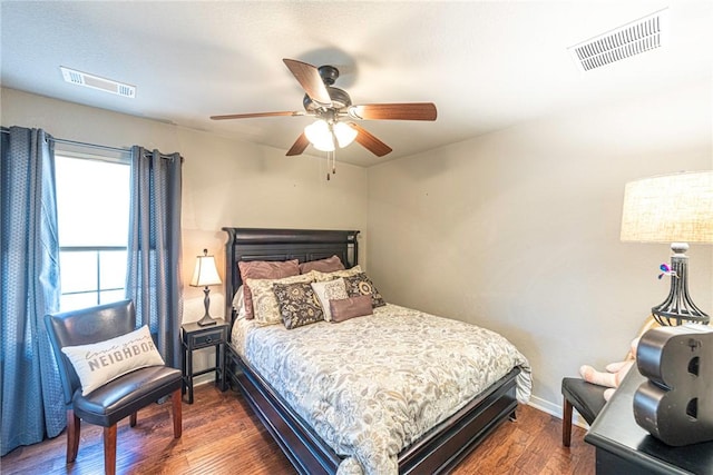 bedroom with dark wood-type flooring, baseboards, visible vents, and ceiling fan