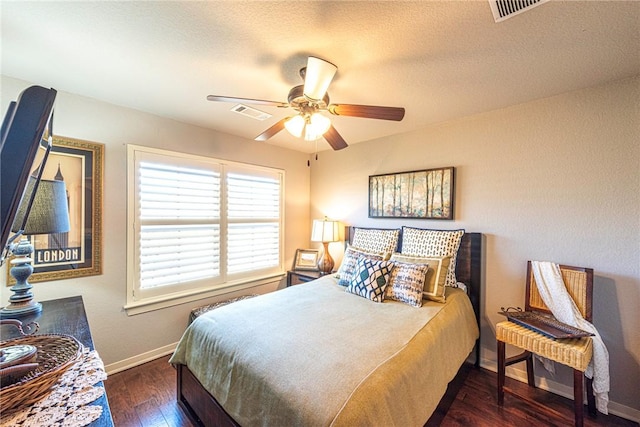 bedroom with visible vents, baseboards, a ceiling fan, and hardwood / wood-style flooring