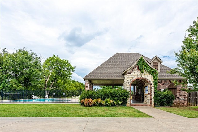 surrounding community with a pool, a yard, and fence