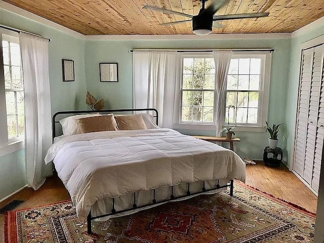 bedroom featuring visible vents, wooden ceiling, baseboards, and wood finished floors