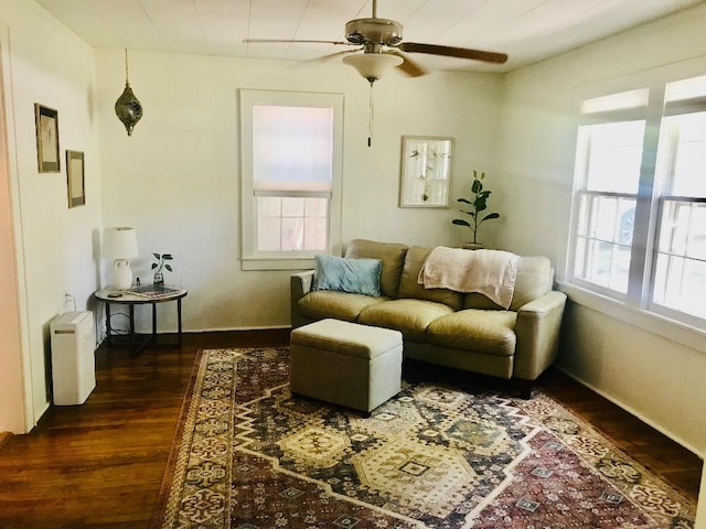 living area featuring plenty of natural light, a ceiling fan, and dark wood-style flooring