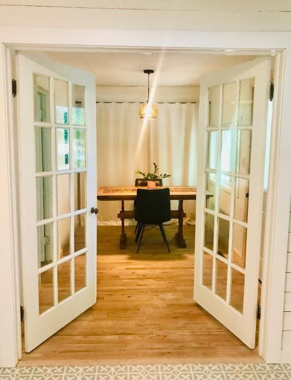 office featuring light wood finished floors, beamed ceiling, and french doors