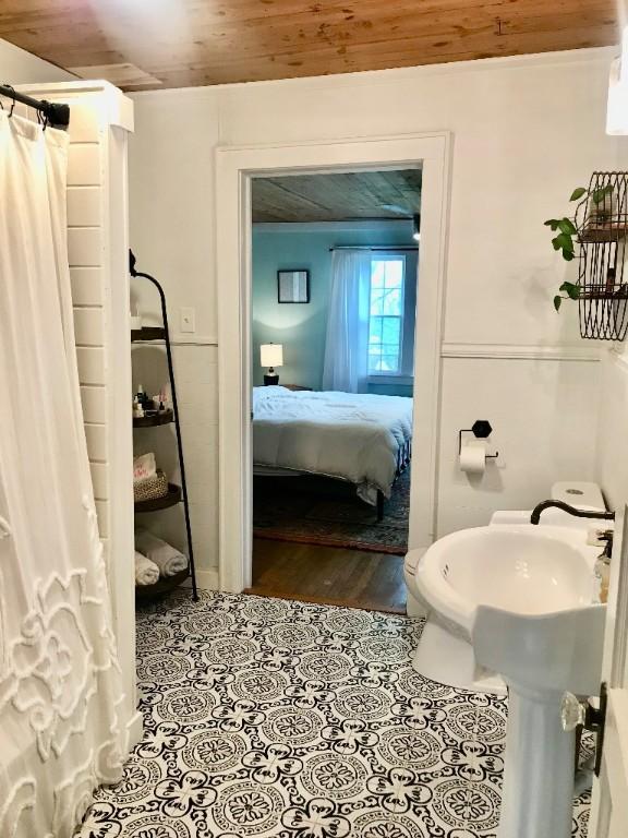 707 W S Ave, Harrison, AR 72601 - bathroom featuring wooden ceiling, ensuite bathroom, curtained shower, and toilet
