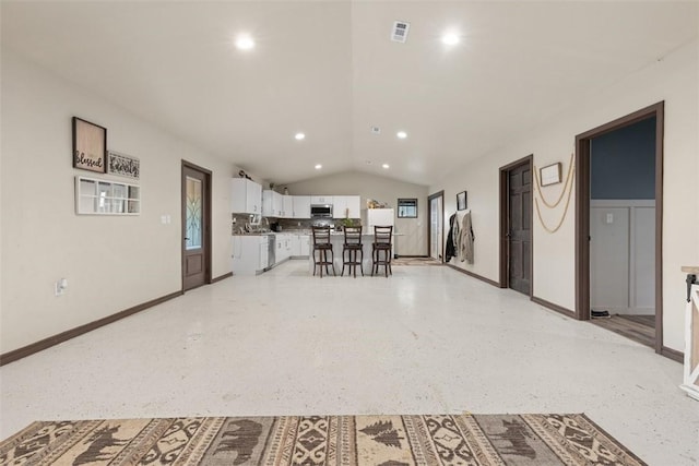 interior space featuring visible vents, recessed lighting, vaulted ceiling, white cabinets, and stainless steel microwave