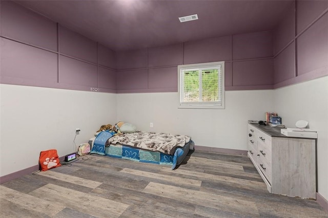 bedroom with visible vents and wood finished floors