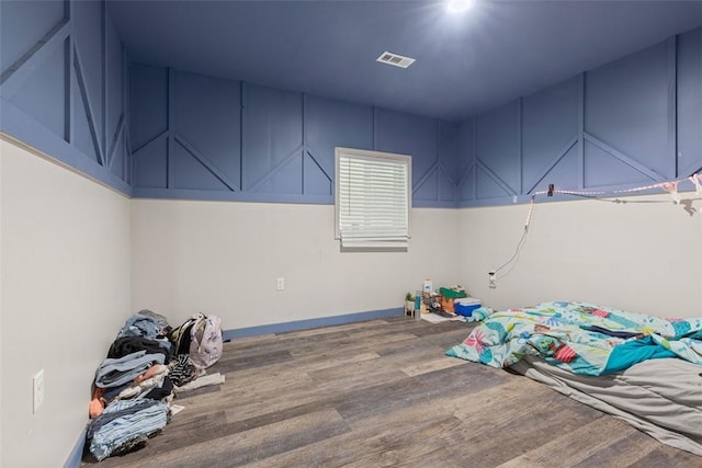 unfurnished bedroom with wood finished floors and visible vents