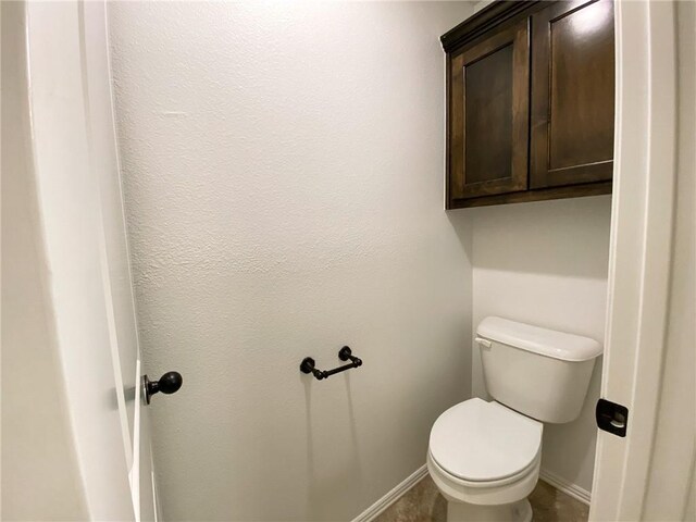 bathroom with toilet and baseboards