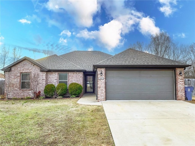 ranch-style home with a front lawn, concrete driveway, an attached garage, a shingled roof, and brick siding