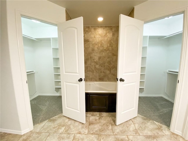 full bath featuring a spacious closet, recessed lighting, and tile patterned floors