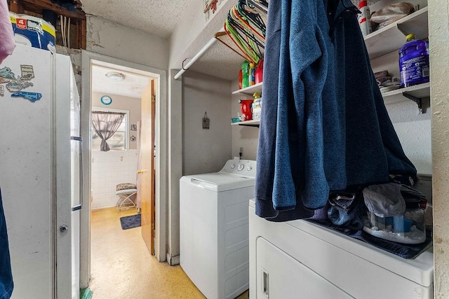 washroom featuring laundry area, washer and dryer, and a textured ceiling