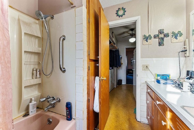 bathroom featuring vanity, a ceiling fan, washtub / shower combination, and a textured ceiling