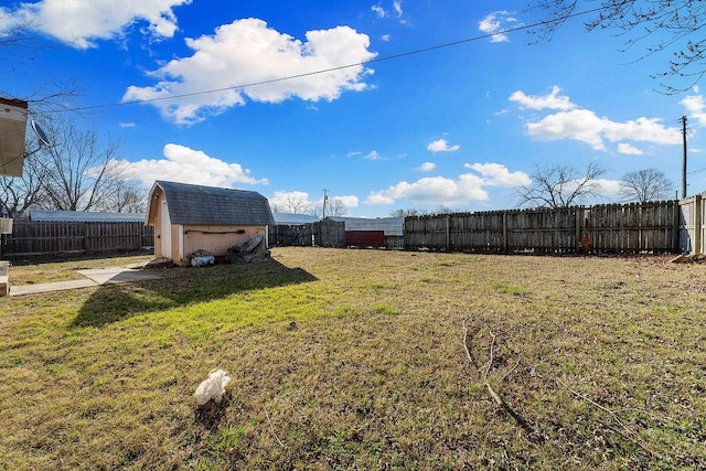 view of yard featuring a fenced backyard, a shed, and an outdoor structure