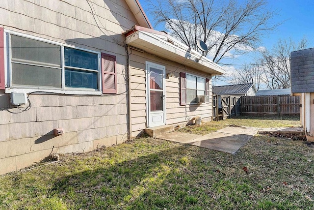 view of property exterior with cooling unit, a lawn, and fence