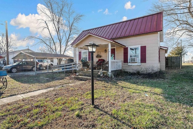 view of front of home with metal roof, covered porch, and a front yard