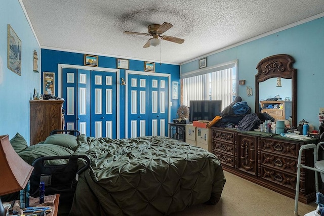 bedroom with two closets, a textured ceiling, carpet, and ornamental molding