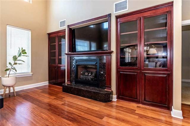 unfurnished living room with visible vents, light wood-type flooring, and a premium fireplace