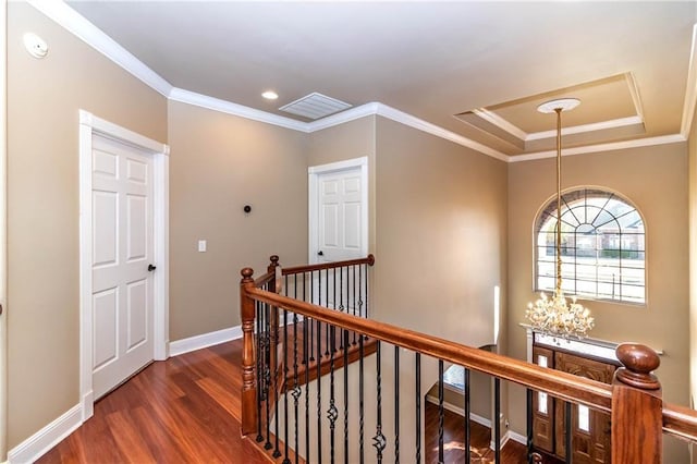 hall featuring wood finished floors, baseboards, visible vents, an upstairs landing, and a chandelier