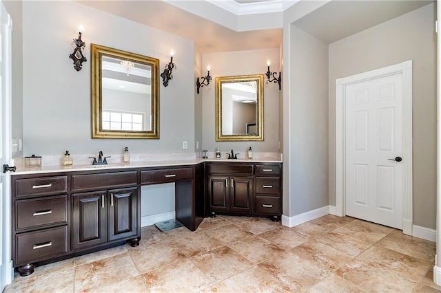 full bath featuring double vanity, baseboards, and a sink